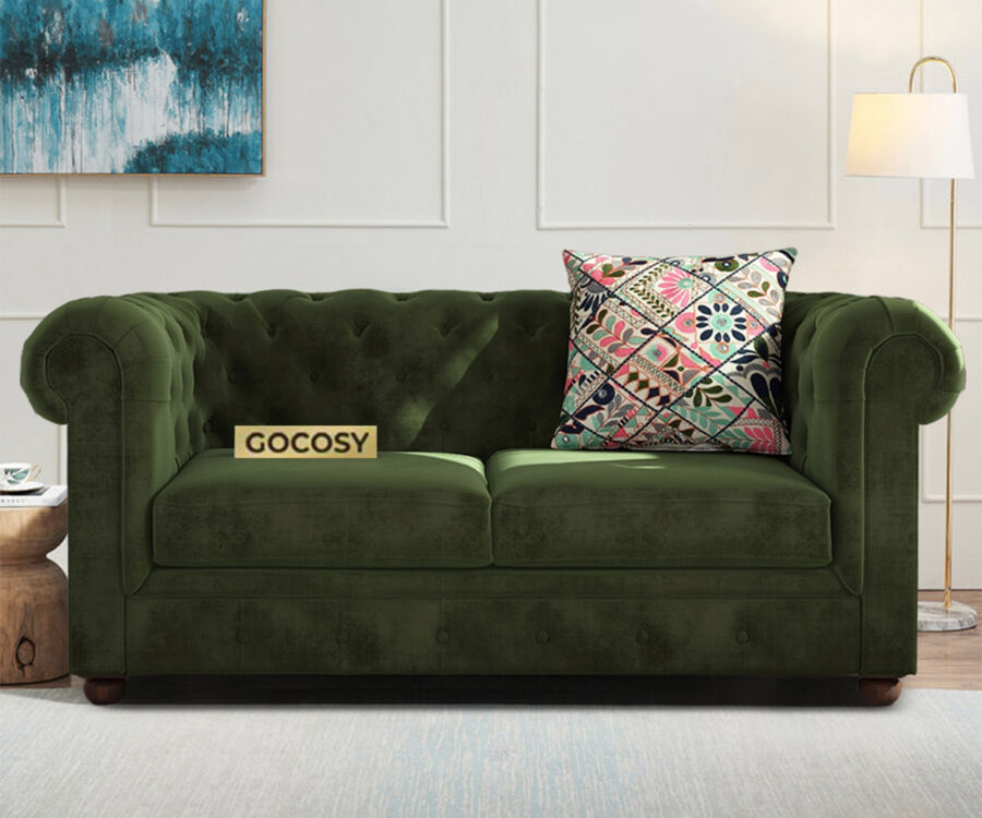 Luxurious Dark Forest Green Chesterfield sofa with deep button tufting, rolled arms, and nailhead trim, adding a classic touch to a living room.