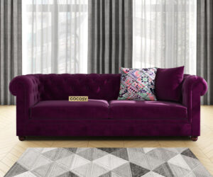 Luxurious Wine Red Velvet Chesterfield sofa with deep button tufting, rolled arms, and nailhead trim, adding a classic touch to a living room.